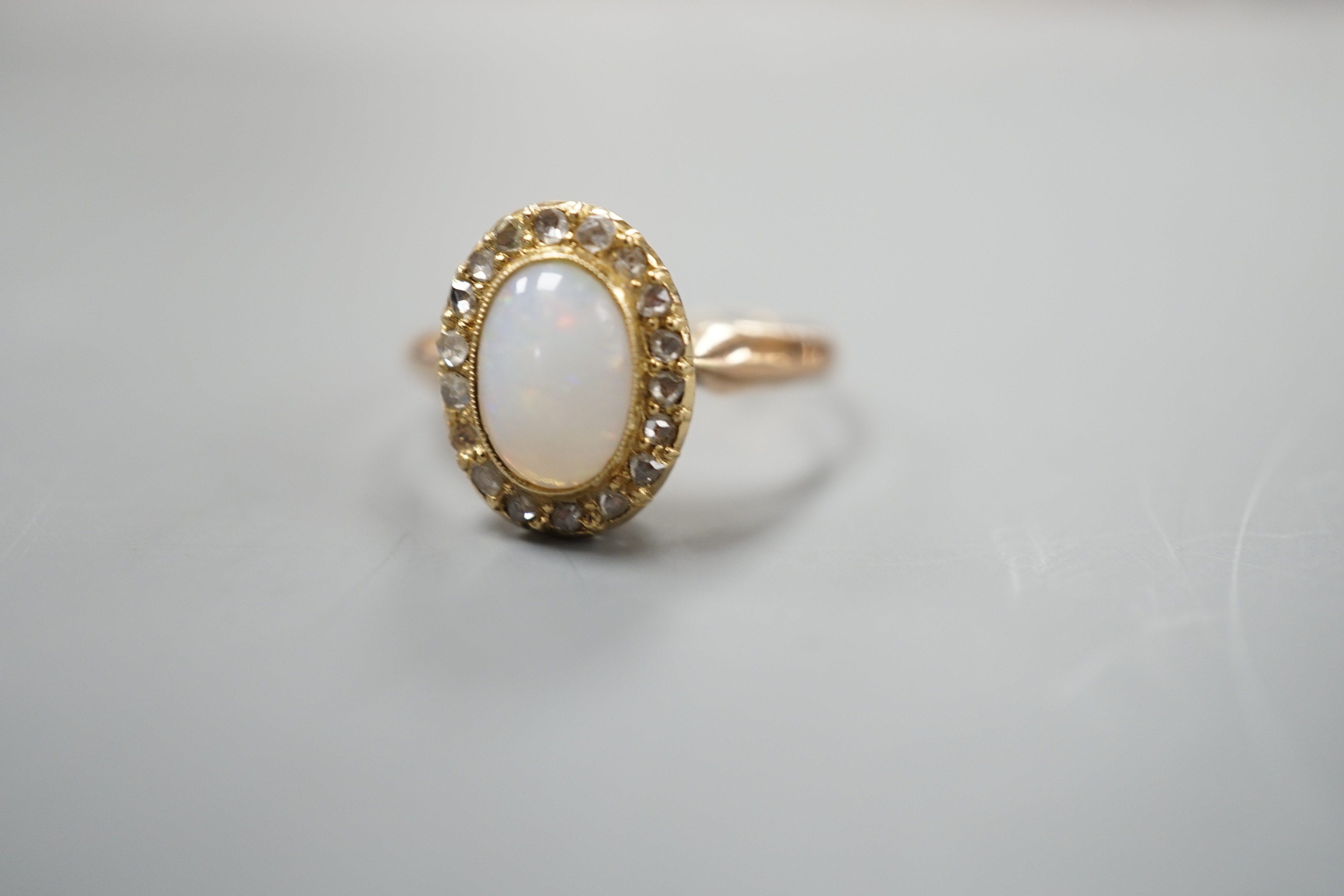 A yellow metal, white opal and rose cut diamond chip set oval ring, size O, gross weight 3 grams.